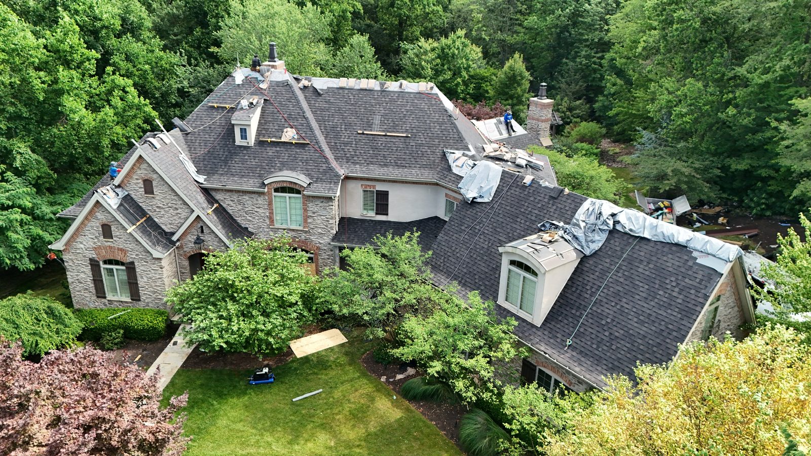 Drone view of a large stone home with a new roof in Lebanon, PA