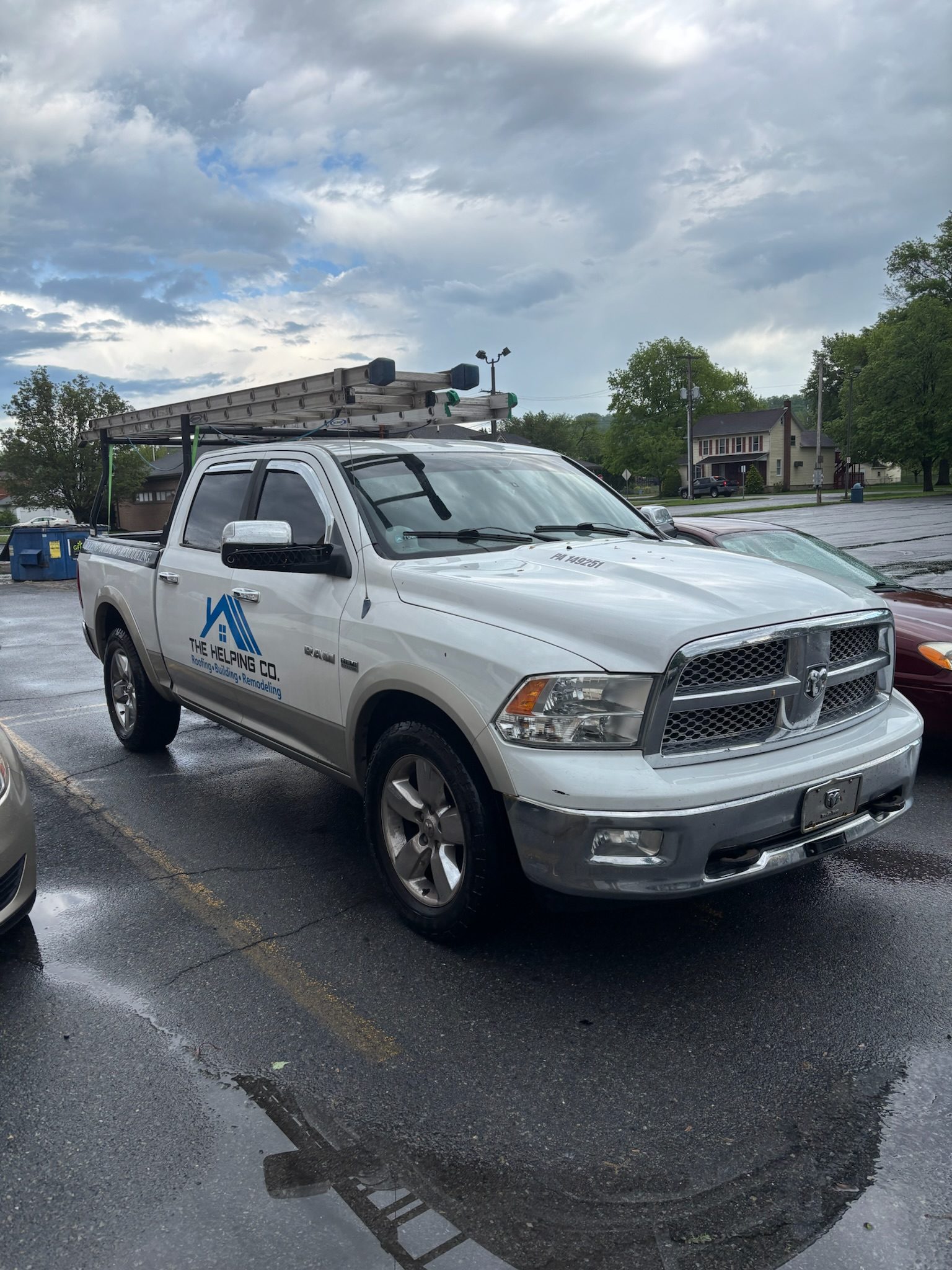 The Helping Co. roofing truck with ladder rack at a job in Wernersville, PA