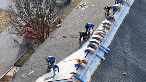 Commercial roof crew installing membrane winter — New Holland, PA