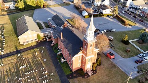 Drone view brick church steeple cemetery — New Holland, PA