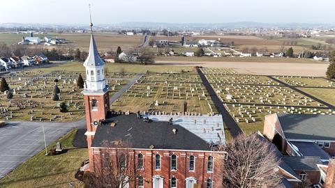 Drone view church steeple cemetery winter — New Holland, PA